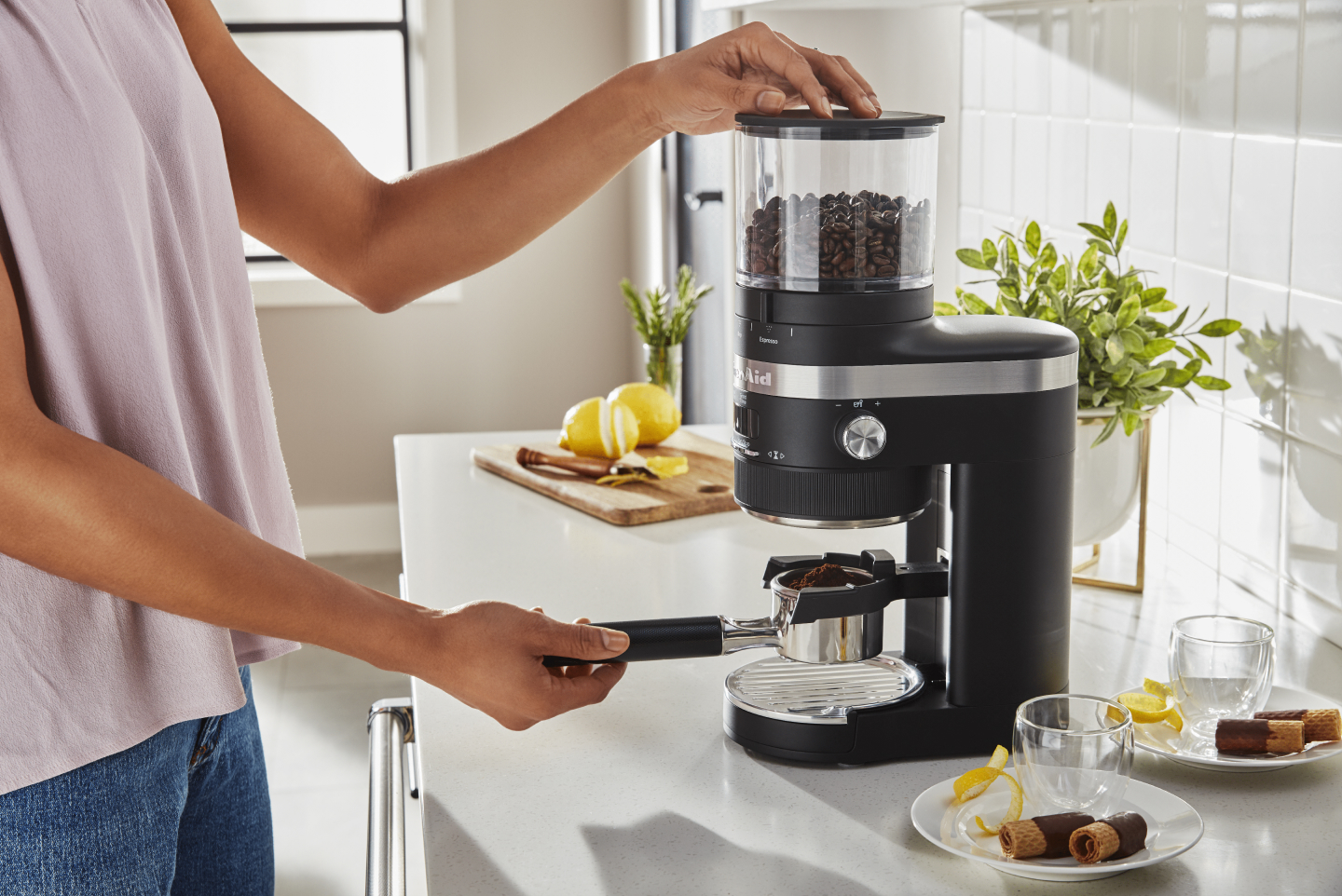 Woman grinding espresso with a KitchenAid® burr grinder Woman grinding espresso with a KitchenAid® burr grinder